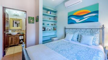 Une chambre à coucher comprenant un lit, une table de chevet, une commode, un miroir et une étagère avec des objets décoratifs.