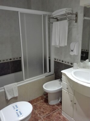 Casa de banho com sanita, bidé e lavatório.