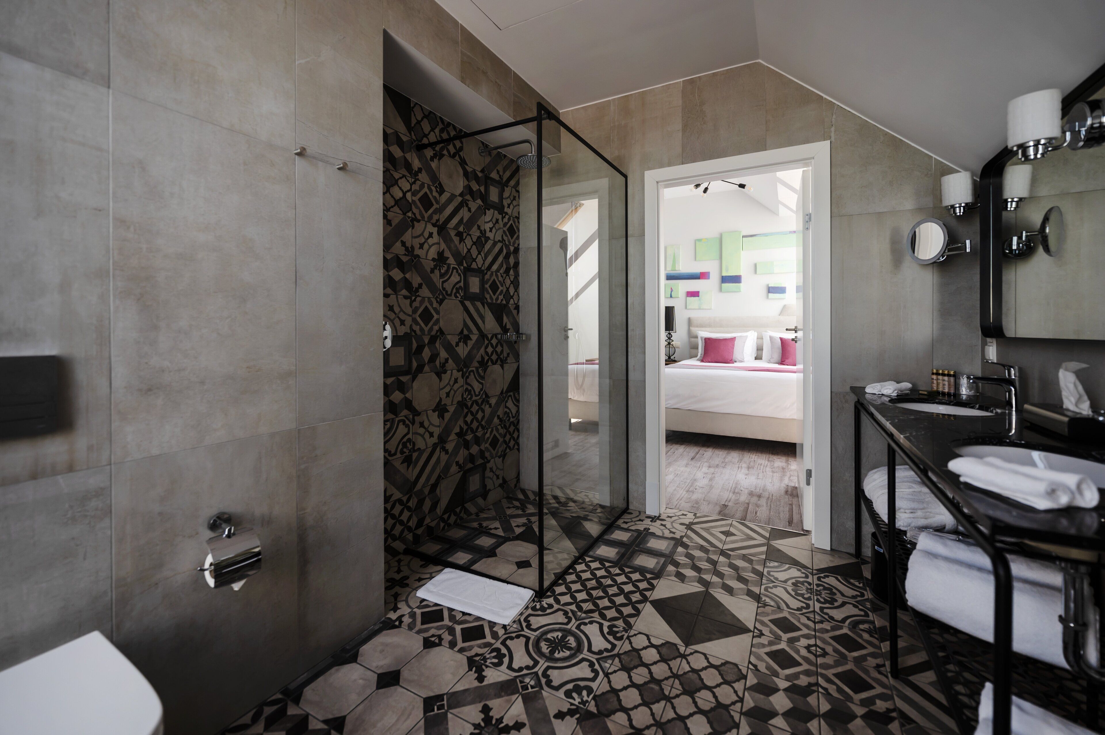 A modern bathroom with a shower, toilet, and sink.