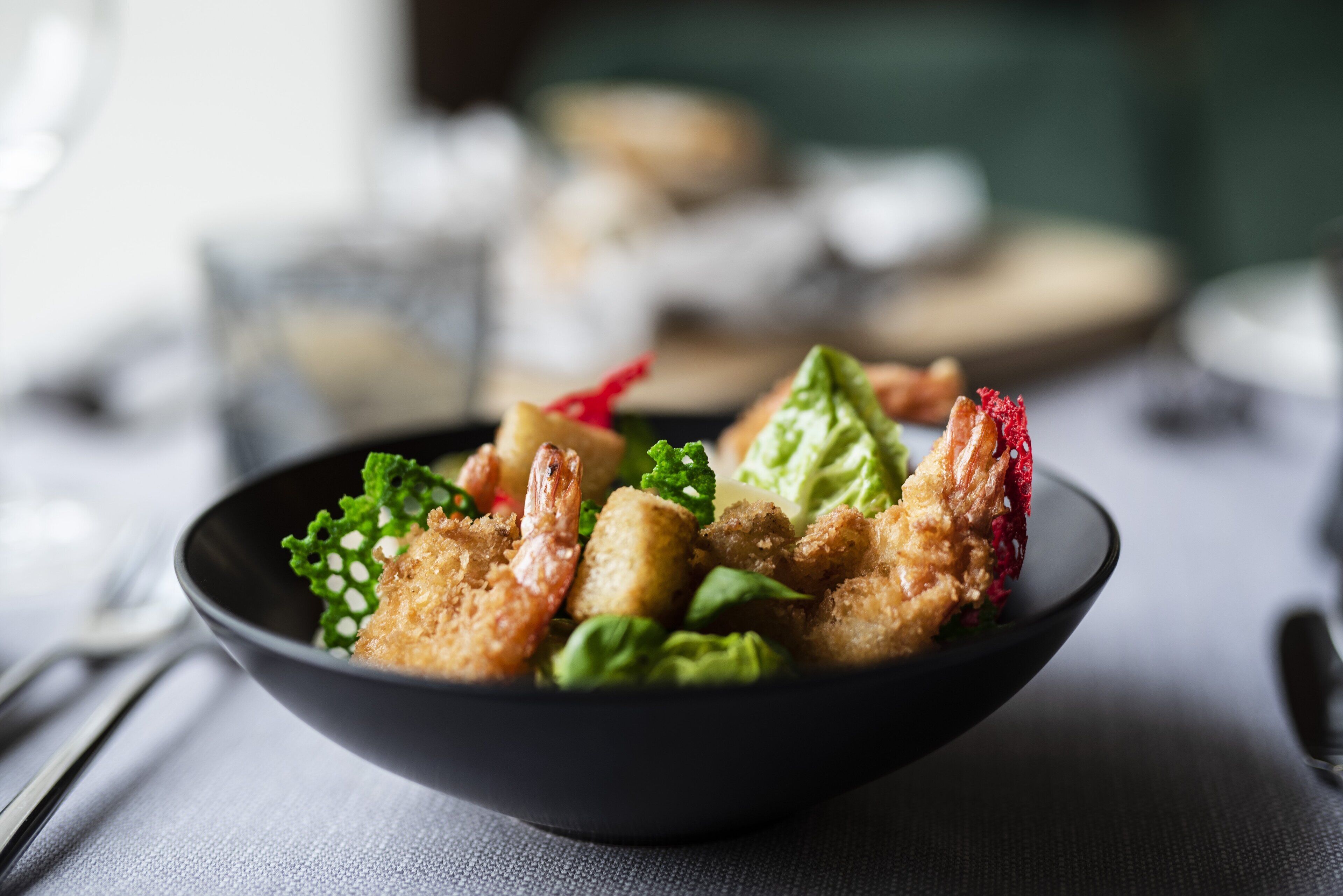 Un plato de comida con camarones, verduras y posiblemente algunos productos empanizados.