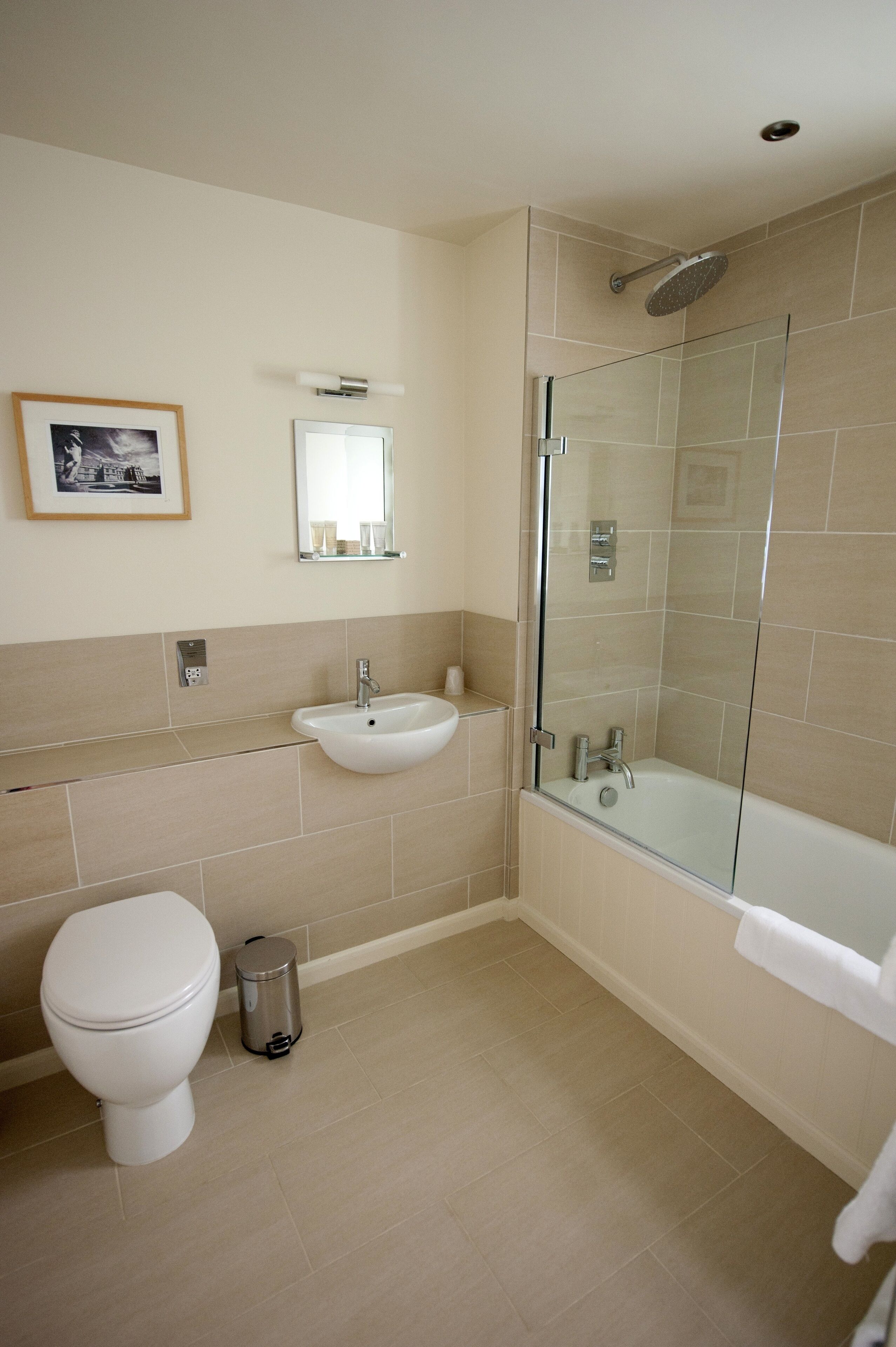 A modern bathroom with a toilet, sink, and glass-enclosed shower.