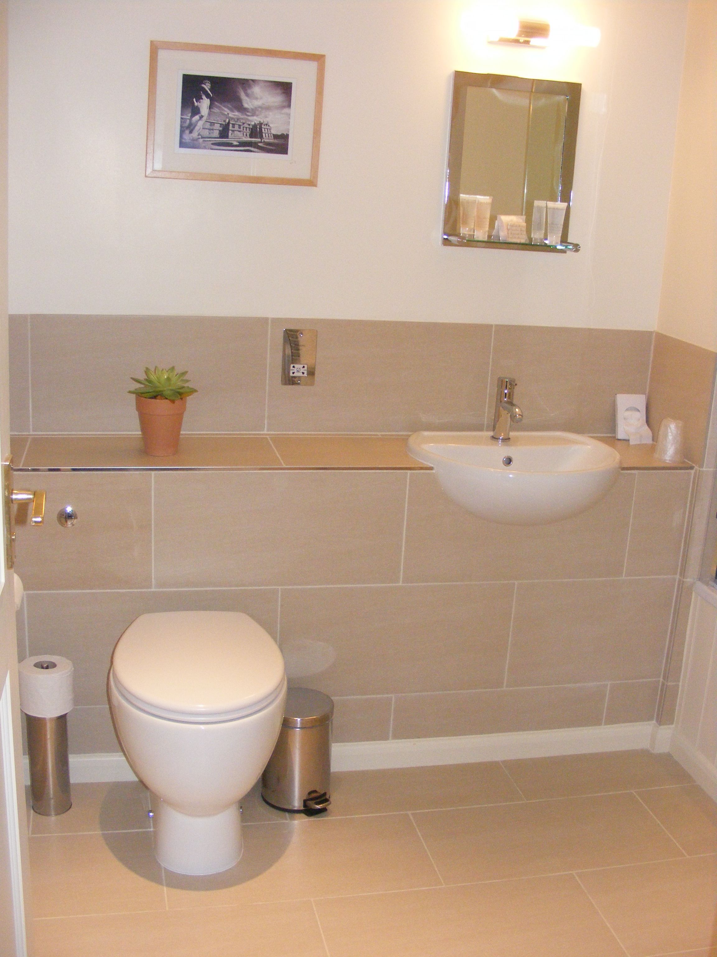 Un baño con inodoro, lavabo y un cuadro en la pared.
