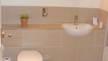 Un baño con inodoro, lavabo y un cuadro en la pared.