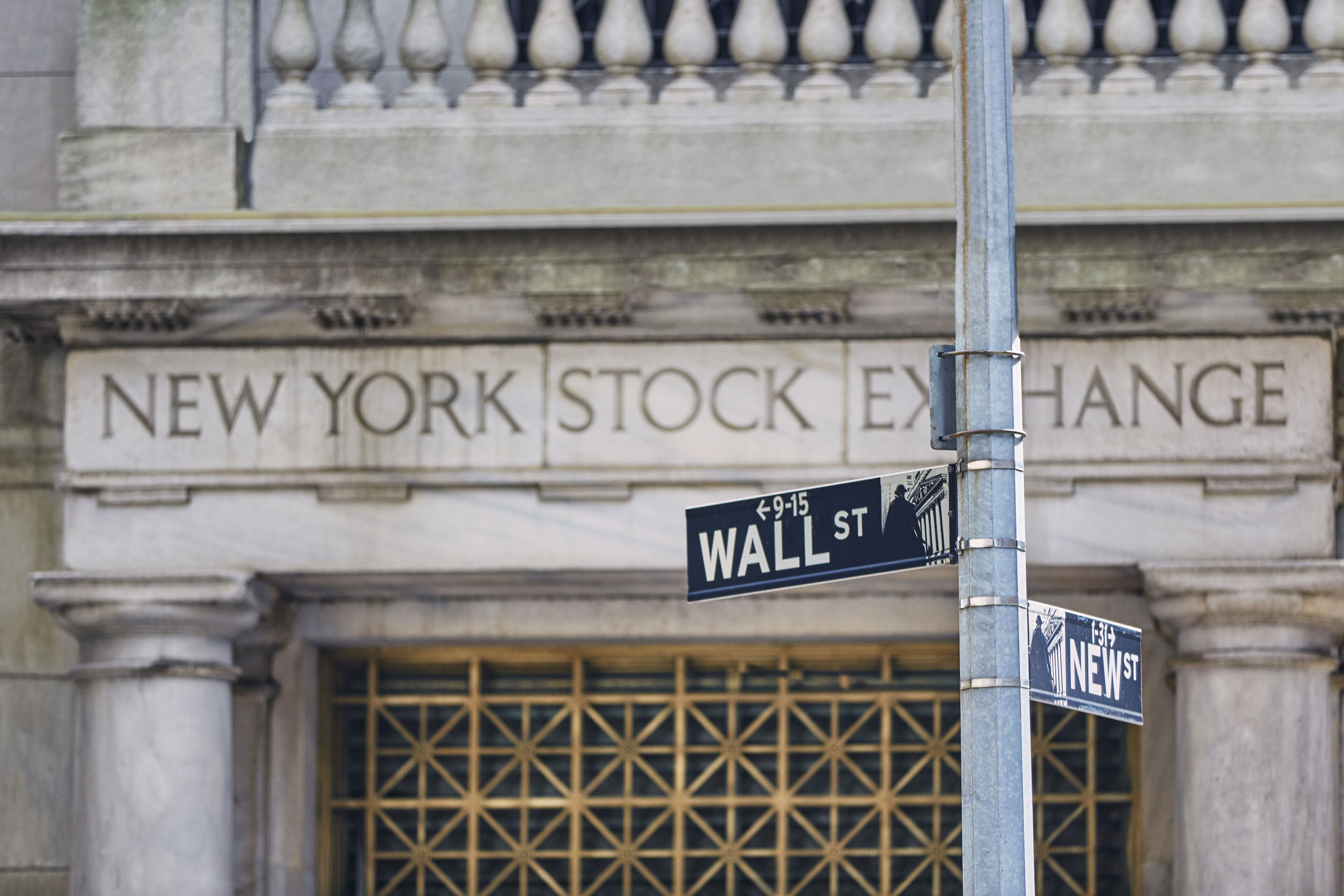 Street signs for Wall St. and New York Stock Exchange.