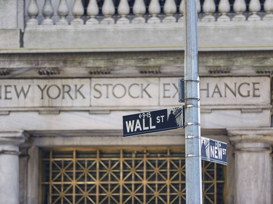 Street signs for Wall St. and New York Stock Exchange.