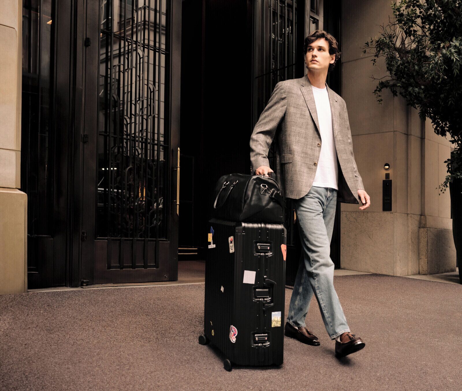A man in a suit with a briefcase walking towards a building entrance.