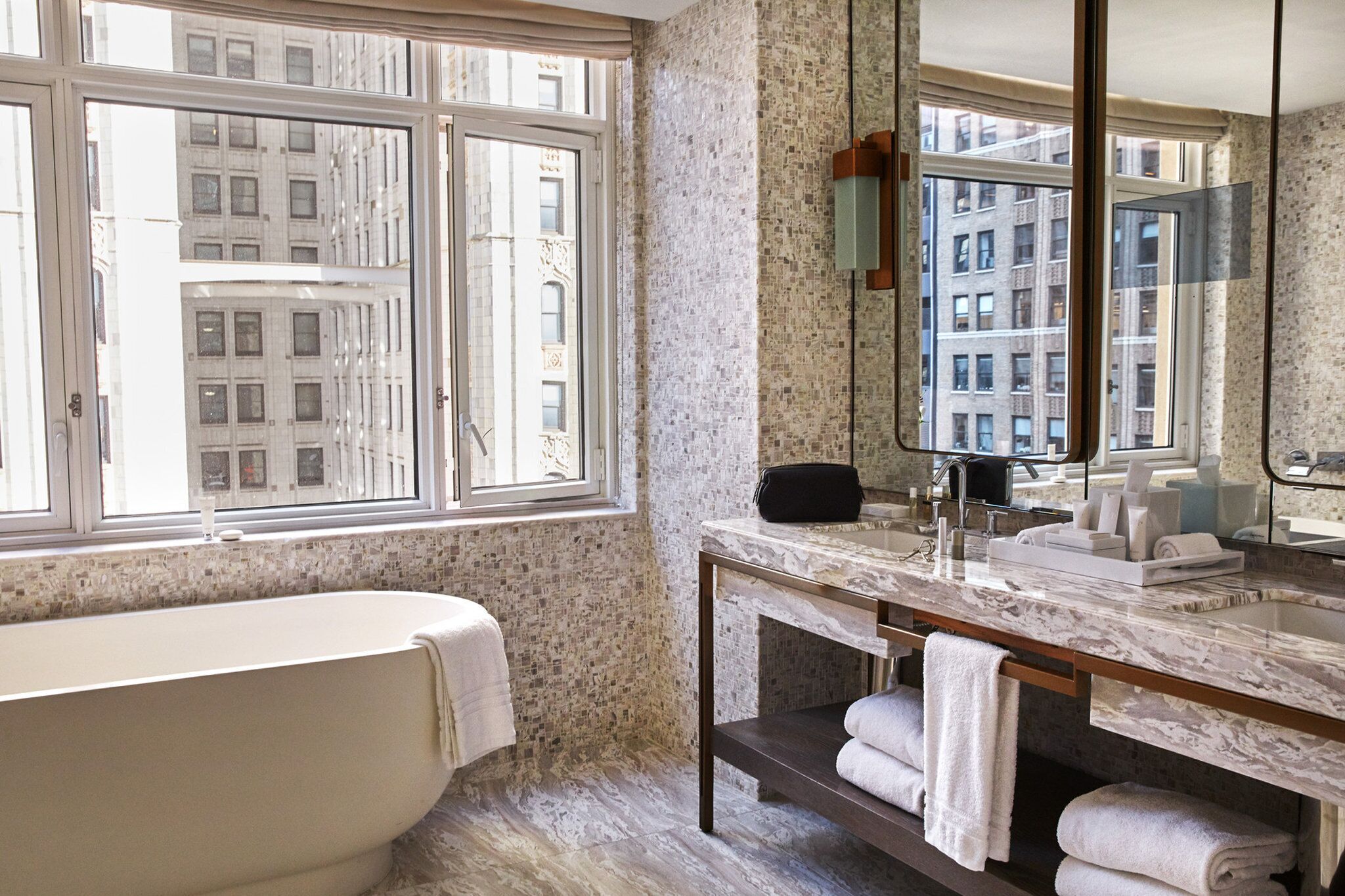 A bathroom with a bathtub, a vanity with a mirror, and towels.