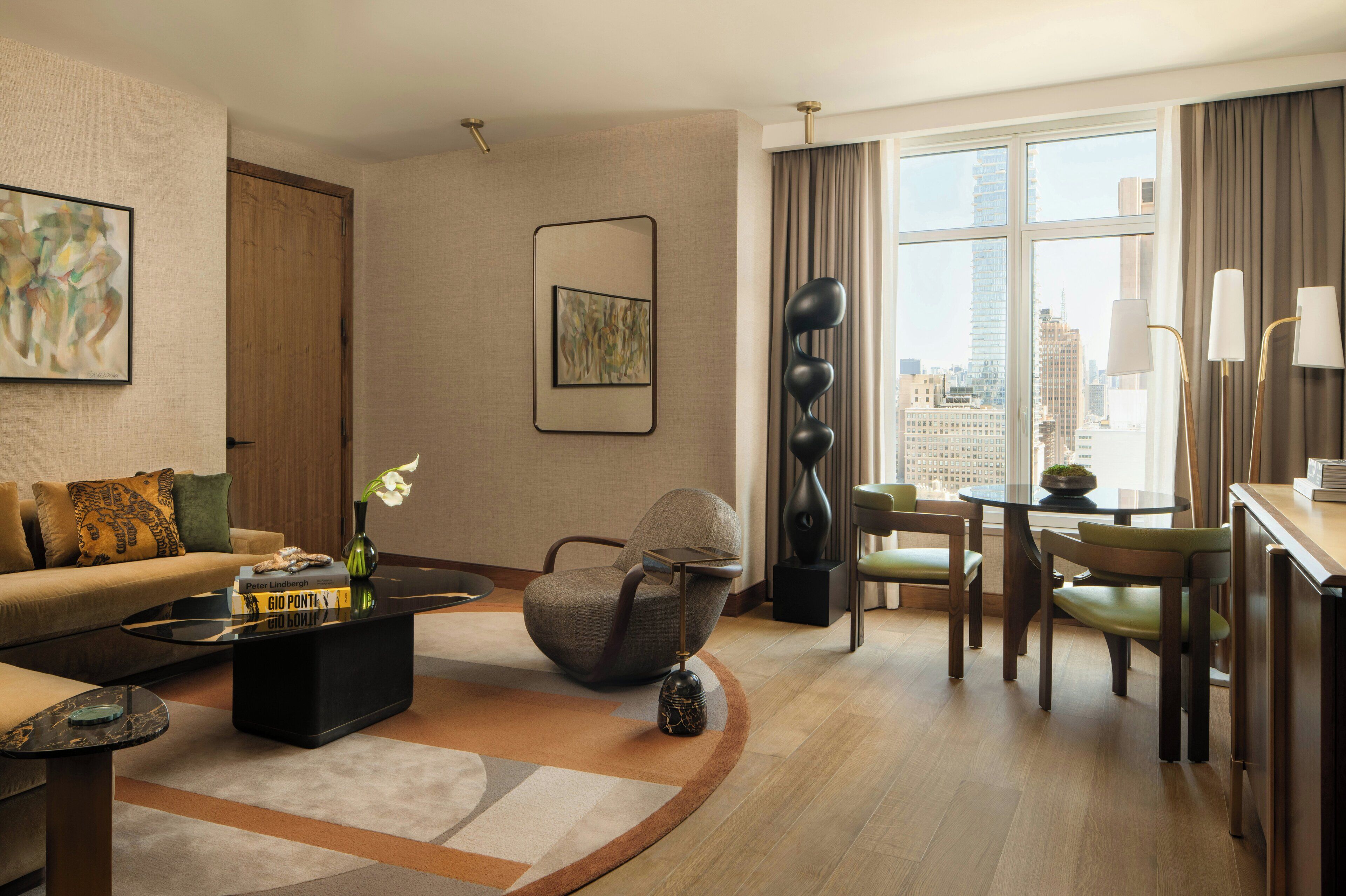 Uma sala de estar moderna com sofá, mesa de centro e uma área de jantar com cadeiras e mesa.