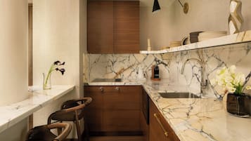 Una cocina moderna con encimeras de mármol, armarios de madera y lavavajillas integrado.