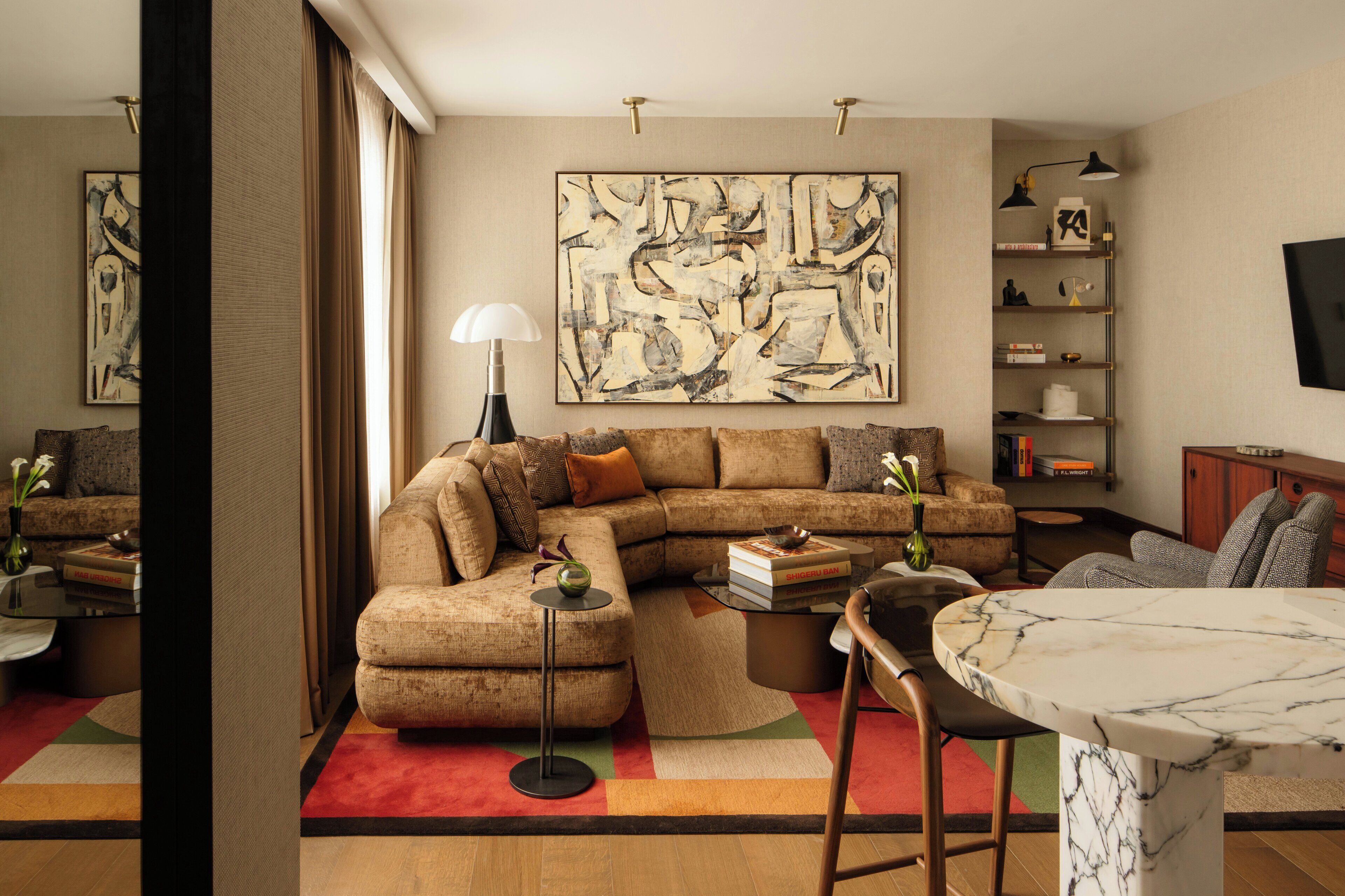 A modern living room with a sectional sofa, a coffee table, and a marble table.