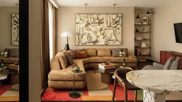 A modern living room with a sectional sofa, a coffee table, and a marble table.