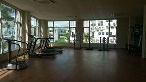 A gym with treadmills, a rowing machine, and a weight bench. - Kiulap Plaza Hotel (Bandar Seri Begawan)