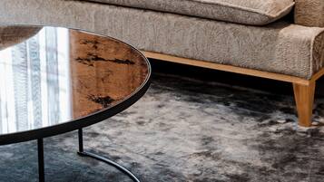 A beige sofa with a patterned fabric and a round coffee table with a metal frame.