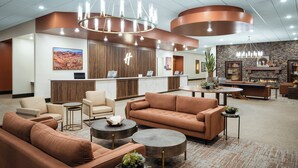 A modern lobby with a reception desk, sofas, and a fireplace. - Holiday Inn Resort Mesquite by IHG (Mesquite)
