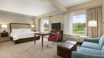 Ein Hotelzimmer mit Bett, Schreibtisch, Stuhl und einer Couch.