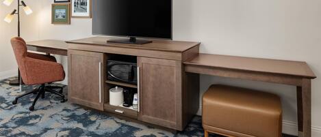 A modern workspace with a desk, chair, and television.