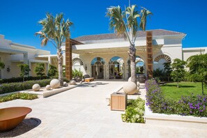 A modern hotel with a central courtyard, palm trees, and a well-maintained garden. - The Shore Club Turks and Caicos (Providenciales)