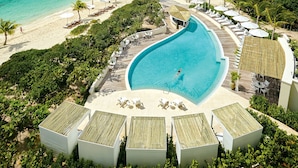 A resort with a large pool, beach, and ocean view.