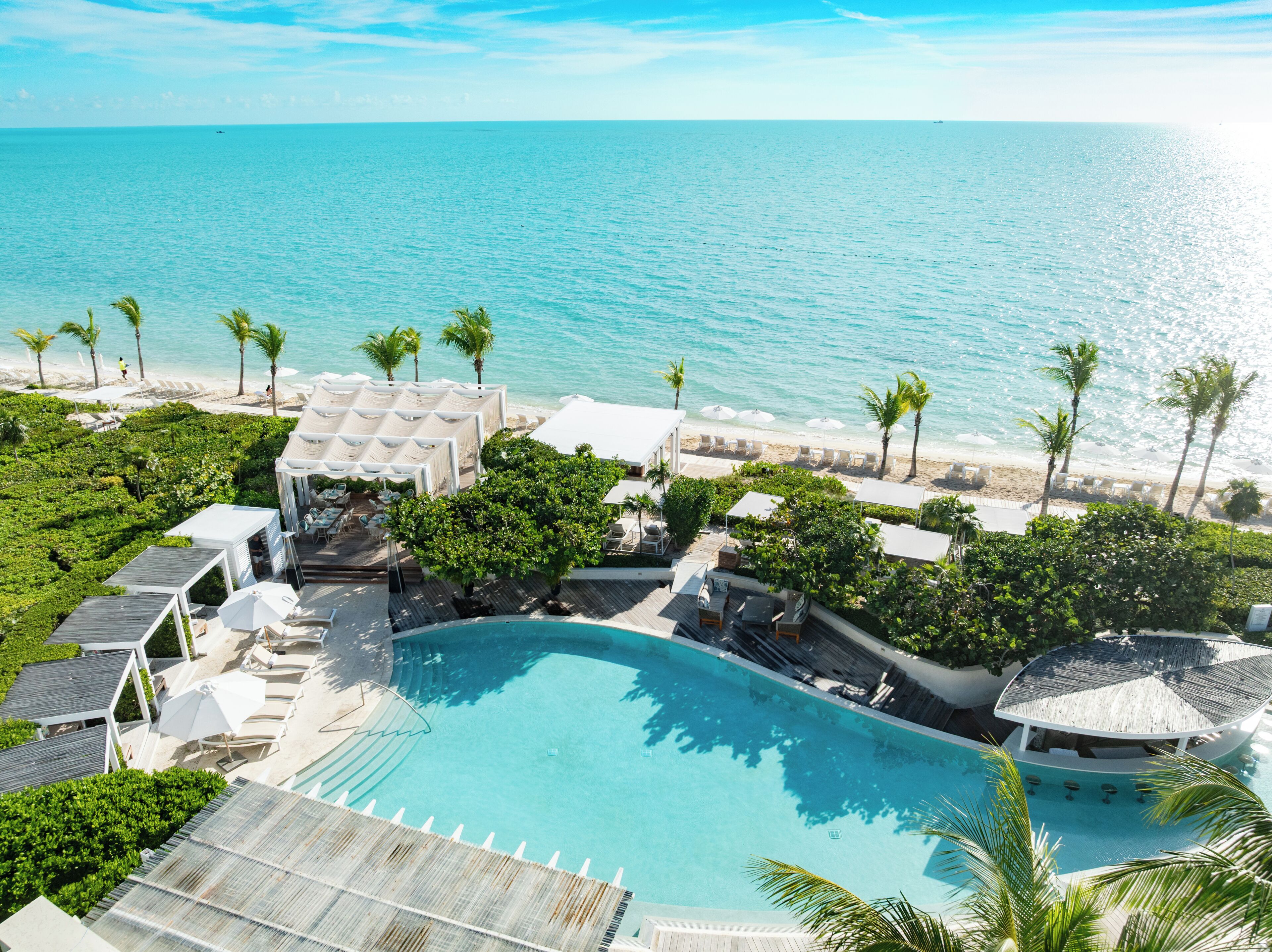 Un complexe hôtelier doté d’une piscine, d’une plage et offrant une vue sur l’océan.