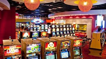 A casino floor with multiple slot machines and a cashier area.