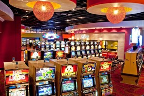 Ein Kasinobereich mit mehreren Spielautomaten und einem Kassenbereich.