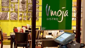 A restaurant interior with a green sign reading "Vmoja BISTRO". - Peermont Metcourt at Umfolozi (Empangeni)