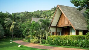 A modern house with a sloped roof, surrounded by lush greenery and a well-maintained garden.