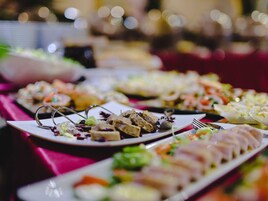 Una mesa de buffet con diversos platos, incluyendo carnes en rodajas, ensaladas y aperitivos.
