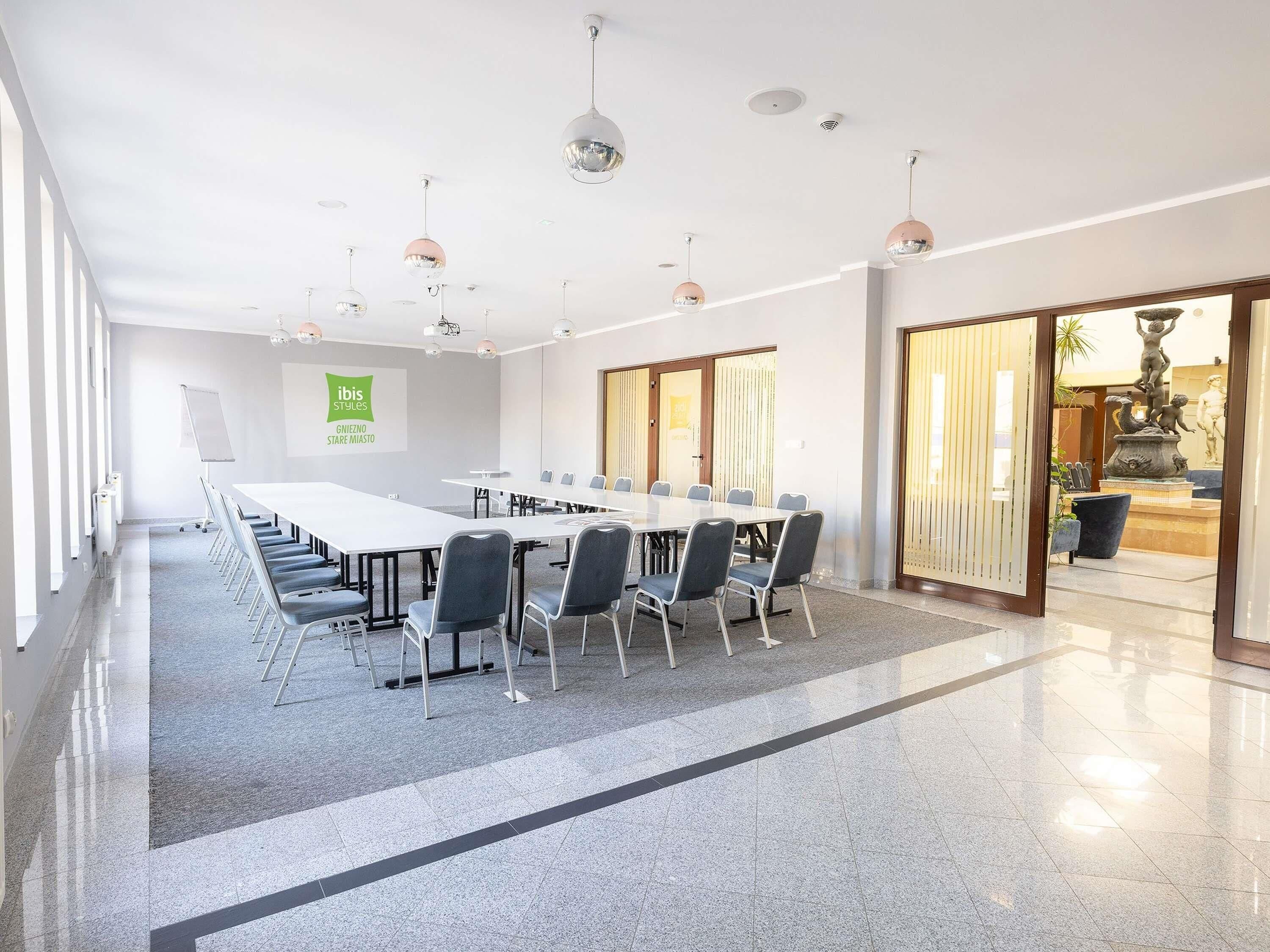 A conference room with a long table, chairs, and ceiling lights.