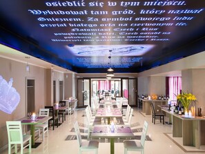 Ein Restaurant mit einem langen Esstisch, Stühlen und einer Bar mit Flaschen.