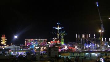 A brightly lit amusement park at night with various rides and attractions.
