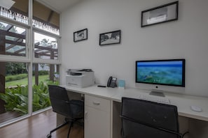 A modern office space with a large desk, two chairs, a desktop computer, a printer, and framed pictures on the wall. - Mercure Maldives Kooddoo Adult-Only Resort (Kooddoo)