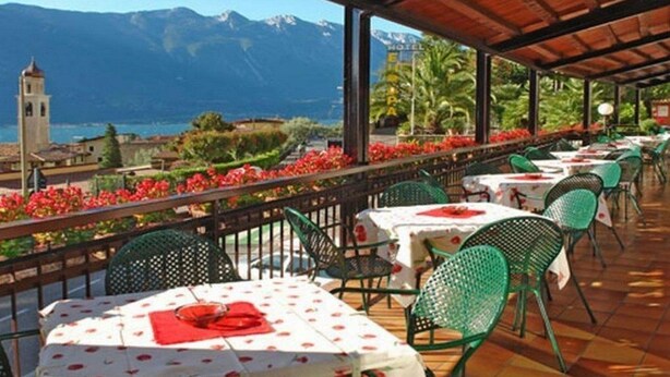 A terrace with tables and chairs, overlooking a mountainous landscape and a body of water. - Europa (Limone sul Garda)