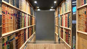 A narrow, well-lit hallway with wooden shelves on either side, filled with books. - ibis Styles La Roche-sur-Yon (Mouilleron-le-Captif)
