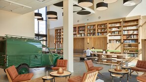 A modern library interior with green vintage car, comfortable seating, and extensive book collections. - ibis Styles La Roche-sur-Yon (Mouilleron-le-Captif)