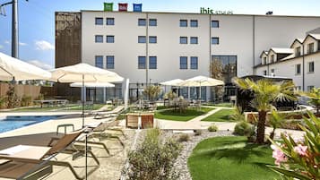 Un hôtel doté d’une piscine, d’un espace extérieur aménagé et d’un jardin bien entretenu.