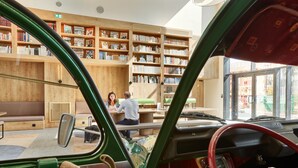 A library with bookshelves, a seating area, and a green car interior. - ibis Styles La Roche-sur-Yon (Mouilleron-le-Captif)