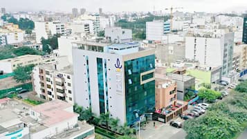A modern building with a prominent logo, surrounded by other urban structures.