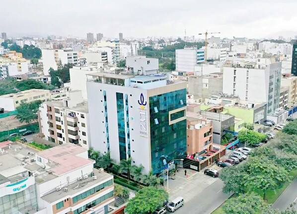 A modern building with a prominent logo, surrounded by other urban structures. - LYZ Business Hotel (Lima)