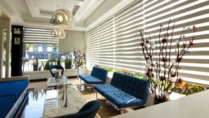 A modern living room with a sofa, chairs, and a coffee table. - LYZ Business Hotel (Lima)