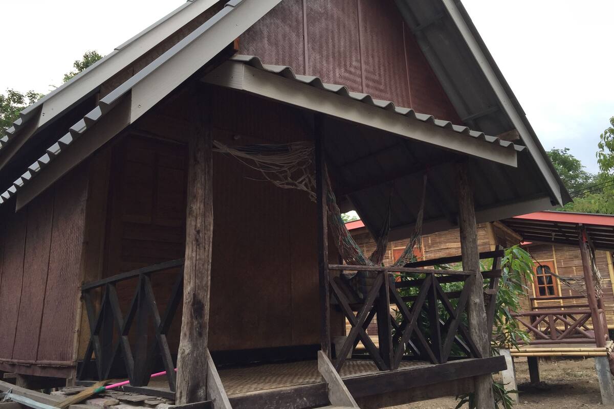 Ein Holzhaus mit geneigtem Dach und einer Veranda.