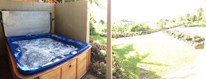 Un bain à remous doté d’un revêtement en bois, installé devant un jardin luxuriant et offrant une vue dégagée sur un paysage vallonné.