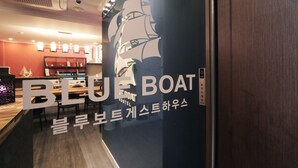 Placa do Blue Boat Hostel com ilustração de um barco, indicando tema náutico.