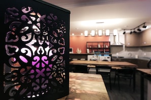 Una cucina moderna con zona pranzo, con un pannello decorativo con motivi traforati.