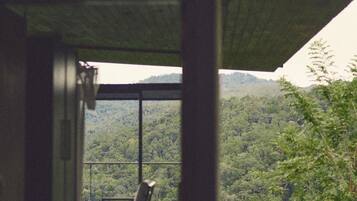 A room with a view of a forested landscape.