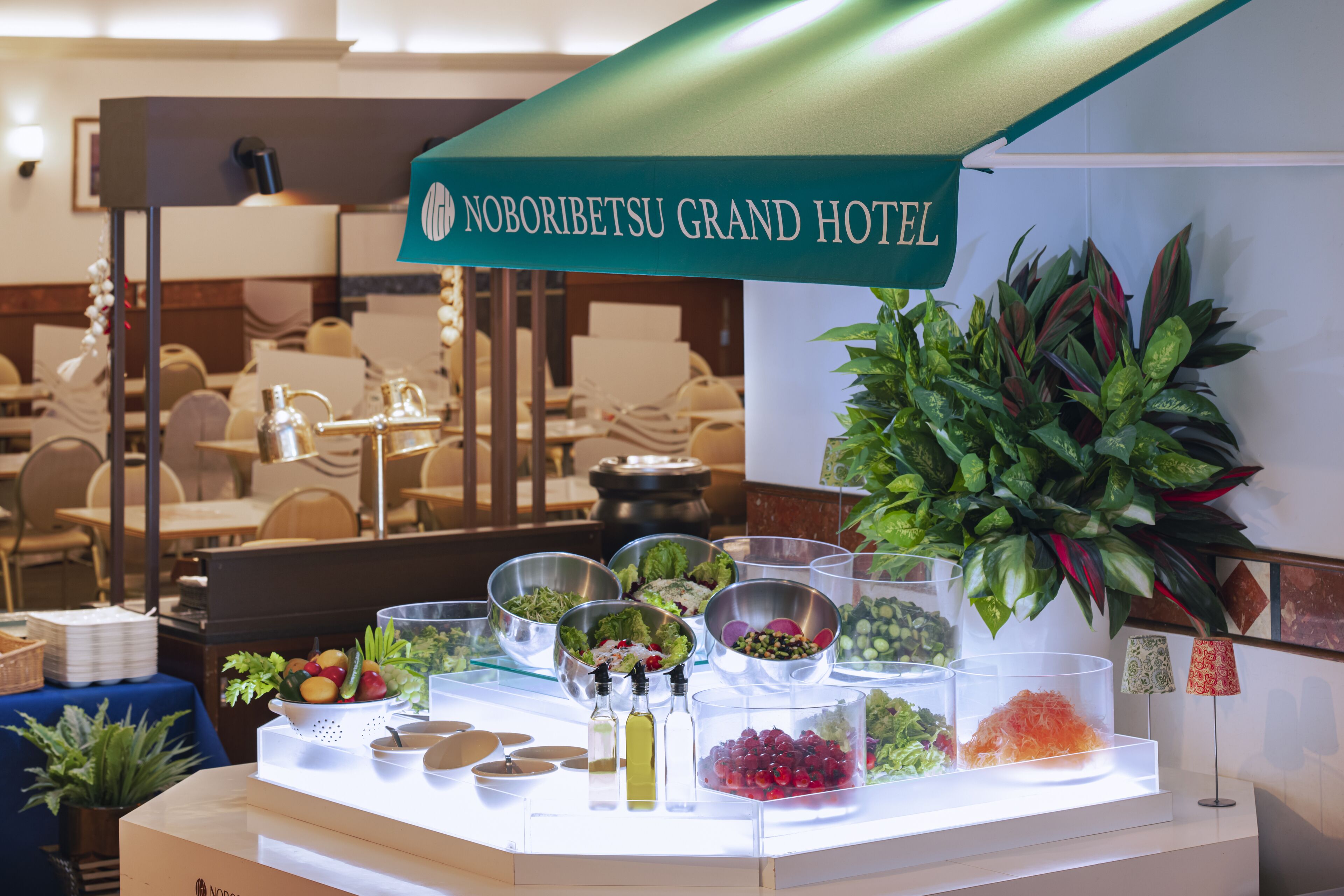 A buffet setup with various food items and a sign for Noboribetsu Grand Hotel.