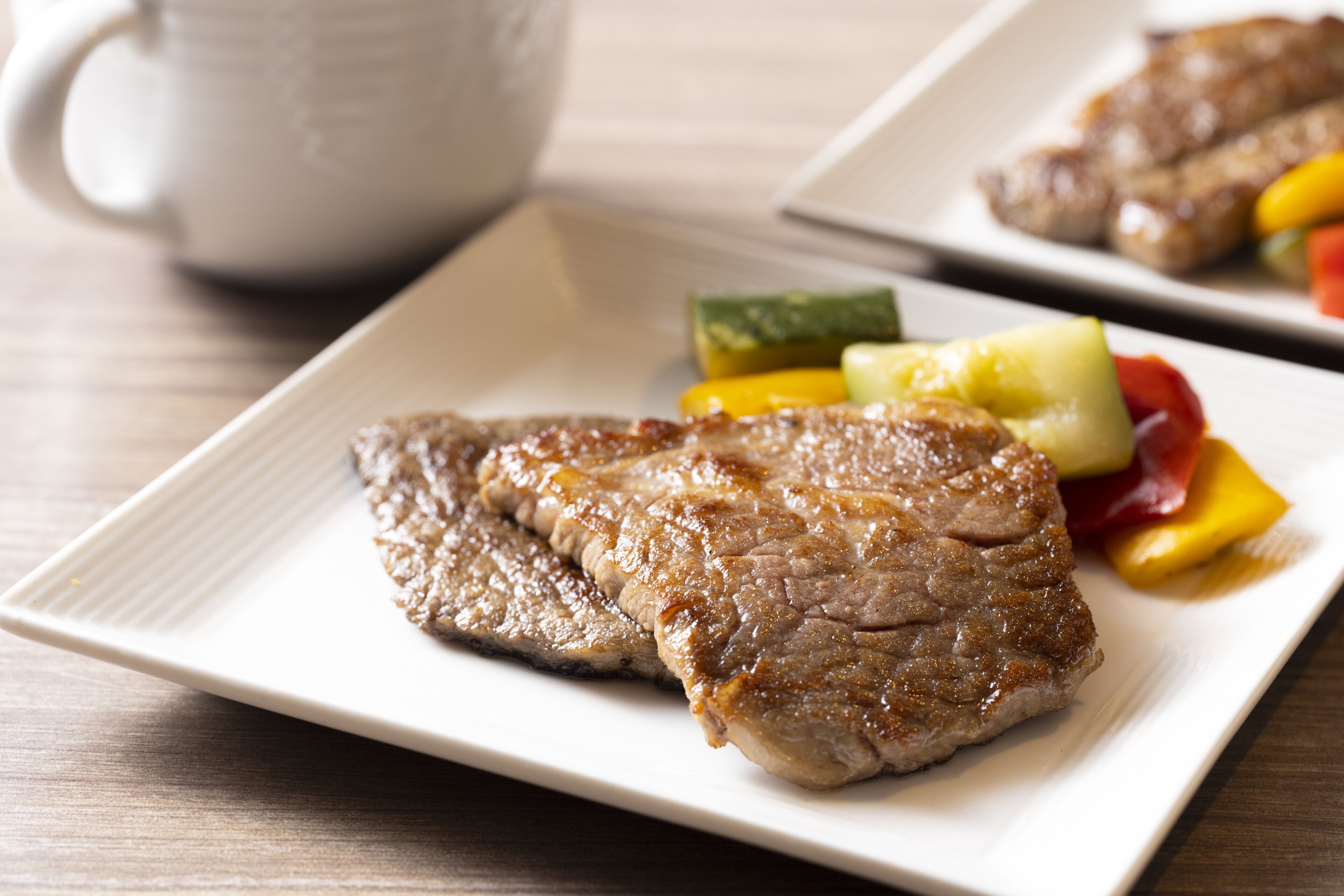 A plate with grilled steak and vegetables.
