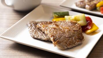A plate with grilled steak and vegetables.