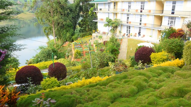 Un hôtel avec vue sur le jardin, une piscine et un bâtiment doté de nombreux balcons.