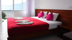 Une chambre d’hôtel avec un grand lit, une tête de lit en bois et une vue sur les montagnes par la fenêtre.